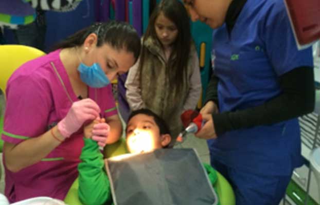 Odontopediatra atendiendo a un niño