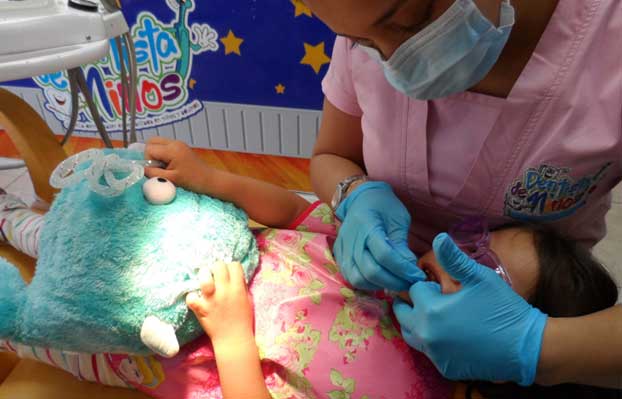 Odontopediatra ayudando a un niño